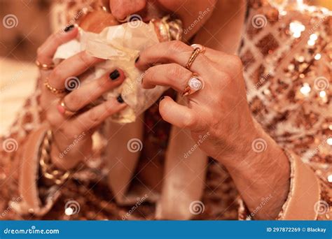 Rich Man In A Shimmering Golden Suit Wearing Golden Rings And Eating