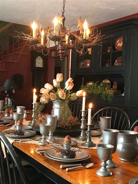 A Dining Room Table Is Set With Silver Dishes And Candles In Front Of