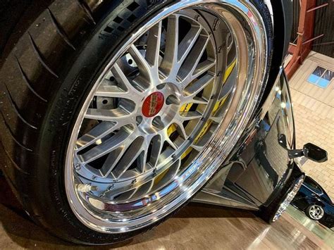 The Wheel And Tire Of A Car With Chrome Rims On Display In A Showroom