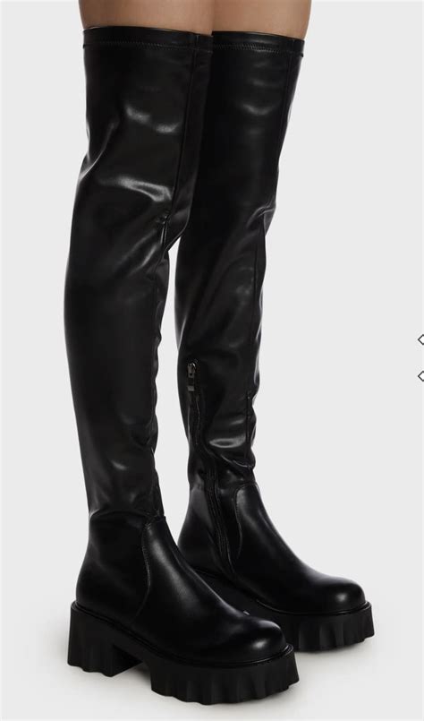 A Woman Wearing Black Boots And Thigh High Boots