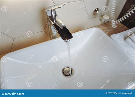 Running Water From Faucet Over Sink A Closeup Shot Of Water Flowing