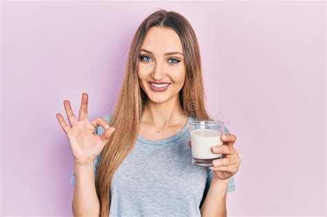 Jeune Fille Blonde Tenant Un Verre De Lait Faire Ok Signe Avec Les Doigts Sourire Amical