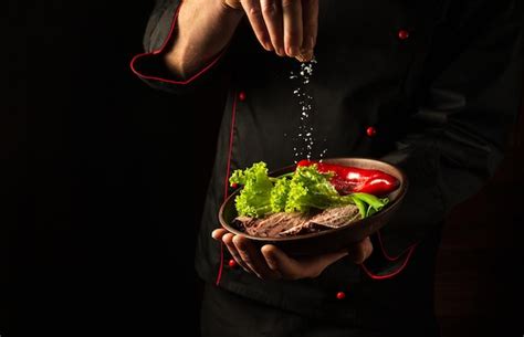 El Chef Roc A Sal En Un Bistec En Rodajas Con Carne Y Verduras En Un