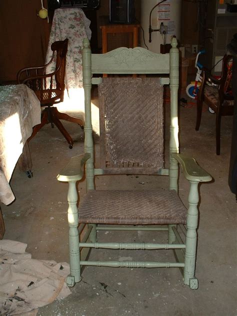 An Old Rocking Chair Is Sitting In The Middle Of A Room