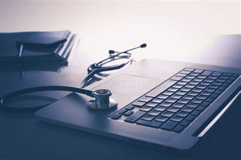 Workplace Of Doctor With Laptop And Stethoscope And Notebook On White