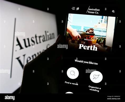 Person Holding Cellphone With Website Of Company Australian Venue Co