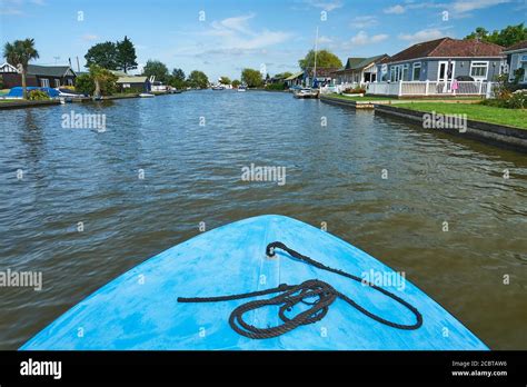 River Thurne Riverbank Lined With Quirky Collection Of Huts And Summer