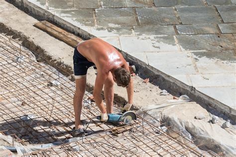 Premium Photo A Naked Worker With Angle Grinder On Construction Site