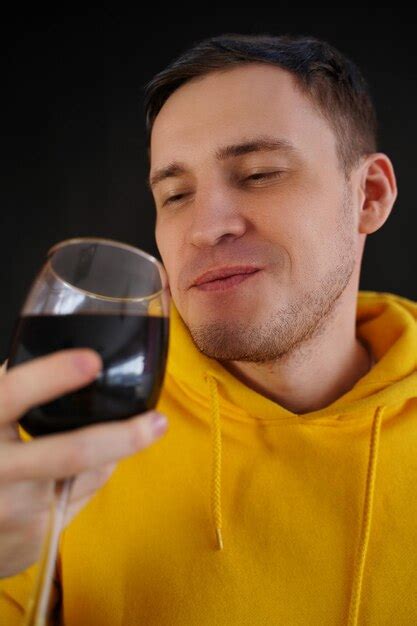 Jovem Relaxado Posa Copo De Vinho Tinto Em Fundo Preto Cara Feliz