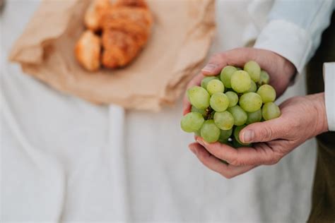 Primer Plano Una Mujer Adulta Sostiene Uvas En Sus Manos Contra El