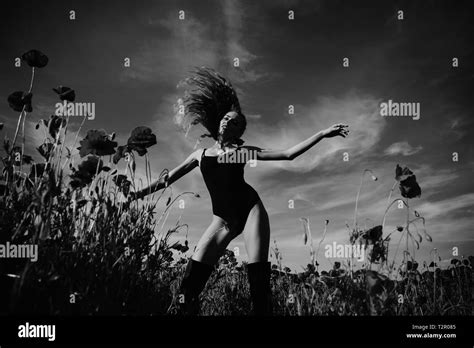 Woman Or Girl With Long Curly Hair In Black Bodysuit In Red Flower