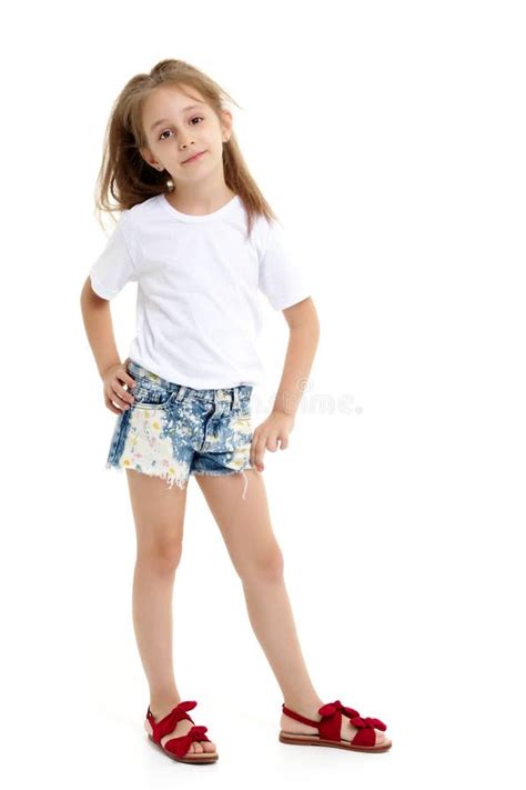 Jeune Belle Petite Fille Blonde En Sport Elle Porte Un T Shirt Blanc Et Des Shorts De Sport