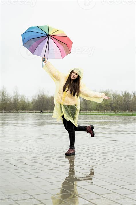 Beautiful Brunette Woman Holding Colorful Umbrella Out In The Rain