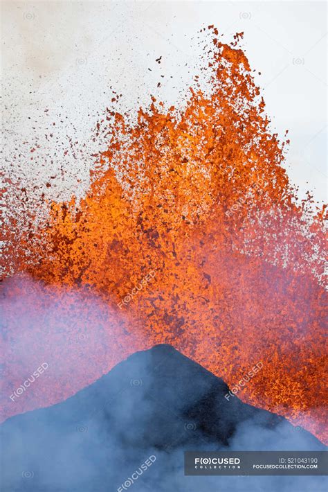 splashes  hot orange lava erupting  volcanic mountain peak