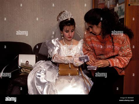 An Iraqi bride in her wedding dress with her sister at a hairdressing ...