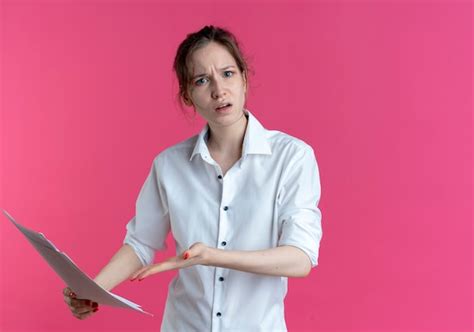 Jeune Fille Russe Blonde Agacée Tient Et Pointe Des Feuilles De Papier Isolées Sur Un Espace