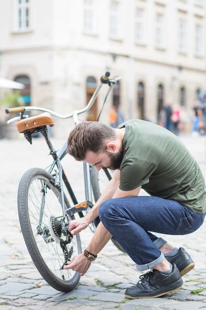 Jovem Reparando Sua Bicicleta Na Rua Na Cidade Foto Gr Tis