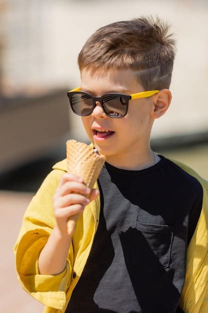 Premium Photo Happy Little Boy Eats Ice Cream In A Waffle Cone In