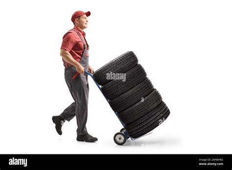 Full Length Profile Shot Of A Worker Pushing Car Tires With A Hand