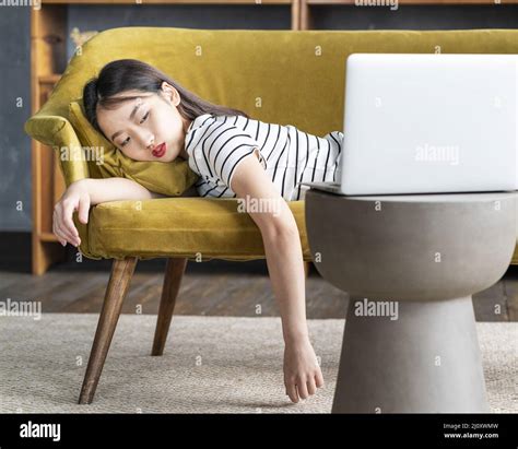 Une Jeune Fille Asiatique Sest Endormie Dans Un Canapé Devant Un Ordinateur Portable Mignonne