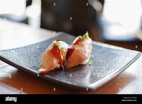 Seared Salmon Nigiri Sushi On Black Plate Stock Photo Alamy