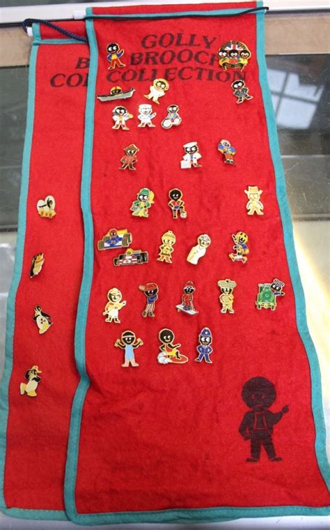 A Collection Of 31 Robertsons Golly Badges On Two Fabric Golly