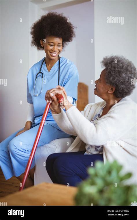 Smiling African American Female Doctor Holding Hands Of Senior Female