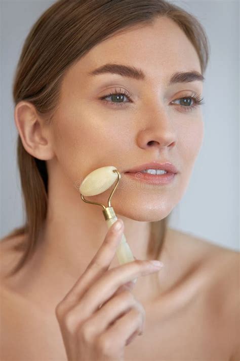 Beauty Skin Care Woman Using Jade Roller For Face Massage Stock Photo