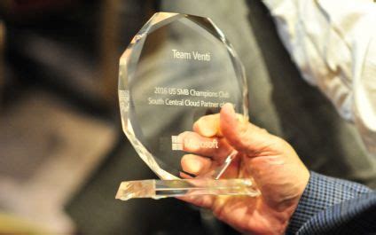 A Person Holding Up An Award In Their Right Hand And The Other Hand Is