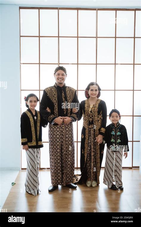 Portrait of a happy family wearing traditional Javanese clothes ...