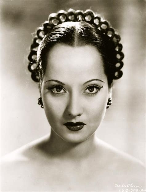 An Old Photo Of A Woman With Pearls In Her Hair And Blue Eyeshadow