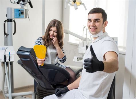 Dentista De Sexo Masculino Amistoso Con El Paciente Femenino Atractivo Después Del Tratamiento