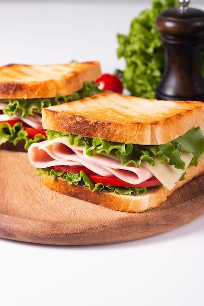 Primer plano de dos sándwiches tostados con jamón fresco queso y