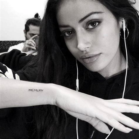 MCMLXIV tattoo in on Cindy Kimberly's right wrist.