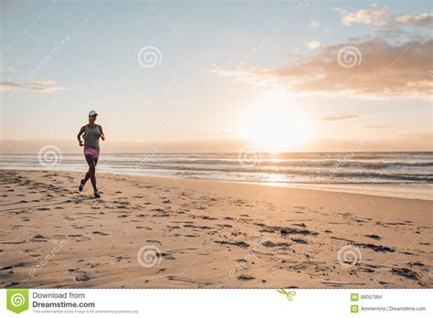 Mujer De La Aptitud Que Hace Ejercicio Corriente En La Playa Foto De