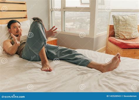 Asian Man Lie On Bed And Relax In His Apartment On Warmth Sunday Summer Spring Stock Image