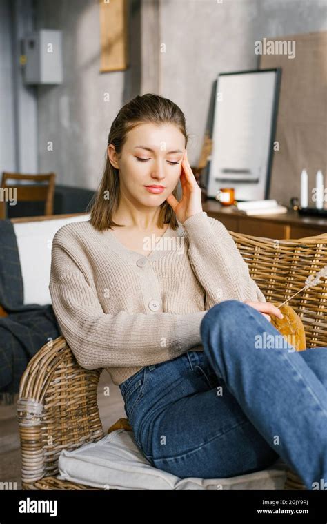 Une Belle Jeune Femme En Jean Et Un Pull Est Assise Sur Une Chaise En