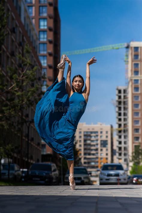 Beautiful Asian Ballerina In Blue Dress Posing In Splits Outdoors