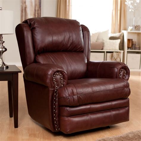 A Brown Leather Recliner Chair Sitting In A Living Room Next To A Table