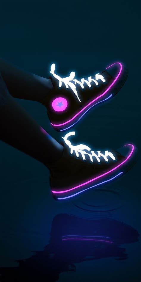 A Pair Of Neon Shoes Is Glowing In The Dark With Their Soles Lit Up