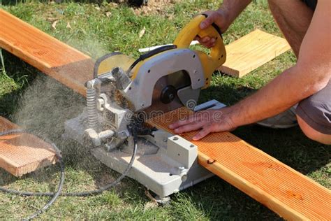 A Worker Saw Wood With A Chop Saw Stock Photo Image Of Nature Green