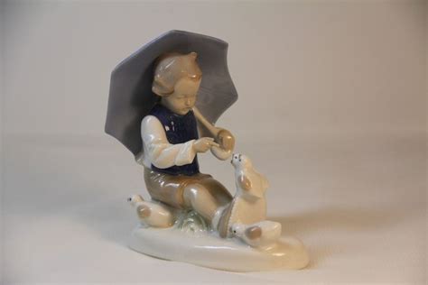 A Ceramic Figurine Holding An Umbrella With Two Polar Bears On The