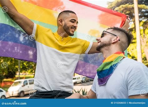 Homopaar Omarmt En Toont Zijn Liefde Voor De Regenboogvlag Stock