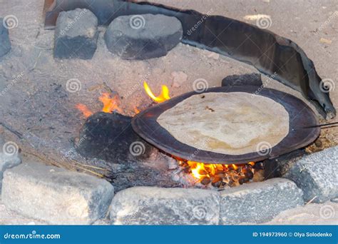 Traditional Arabic Pita Bread Cooking On Fire In Bedouin Dwelling Stock