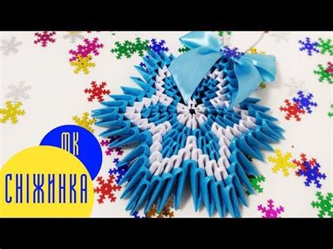 an origami snowflake decoration with blue ribbon and bow on it's side