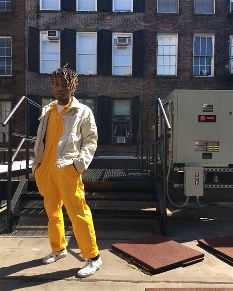 A Man In Yellow Jumpsuit Standing On The Sidewalk