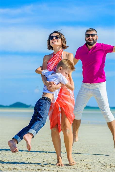 Famille De Trois Fonctionnant Le Long Du Temps De Plage De Rire Et