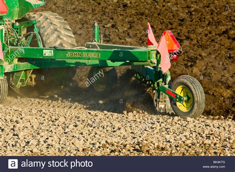 John Deere tractor plowing with reversible plow to prepare the field ...