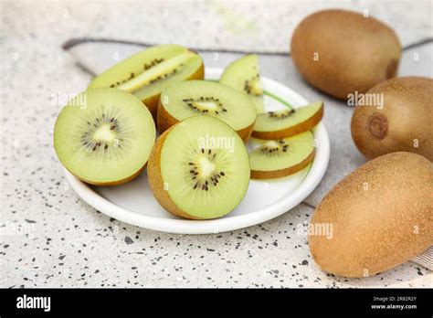 Whole And Cut Fresh Kiwis On White Table With Pattern Closeup Stock