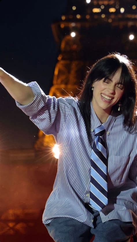 a woman wearing a blue and white striped shirt and tie with her hands ...